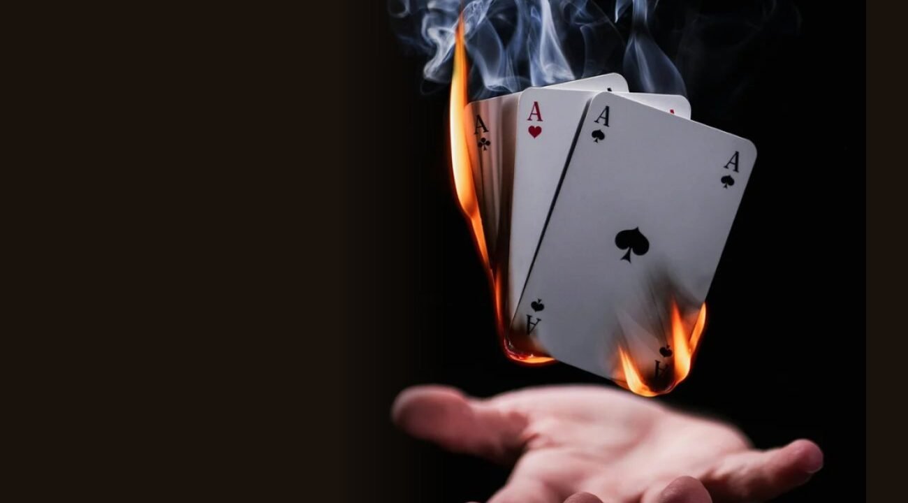 Burning playing cards floating above a hand, from the Brownbeauty Magic supper club