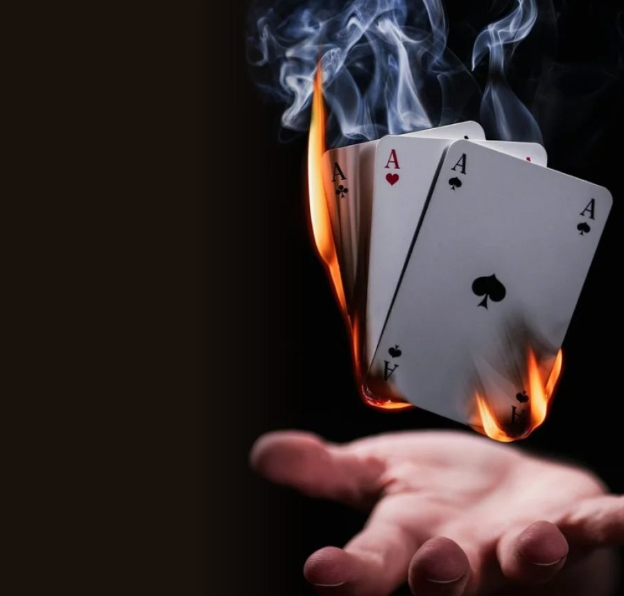 Burning playing cards floating above a hand, from the Brownbeauty Magic supper club
